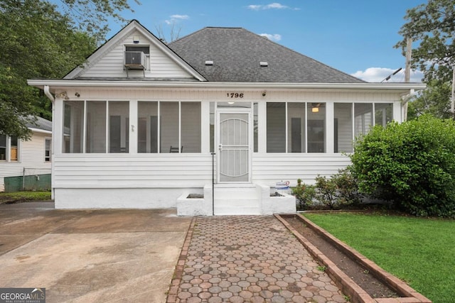 1796 Center Ave, East Point, GA 30344 - view of front of home featuring a sunroom, roof with shingles, a front lawn, and cooling unit