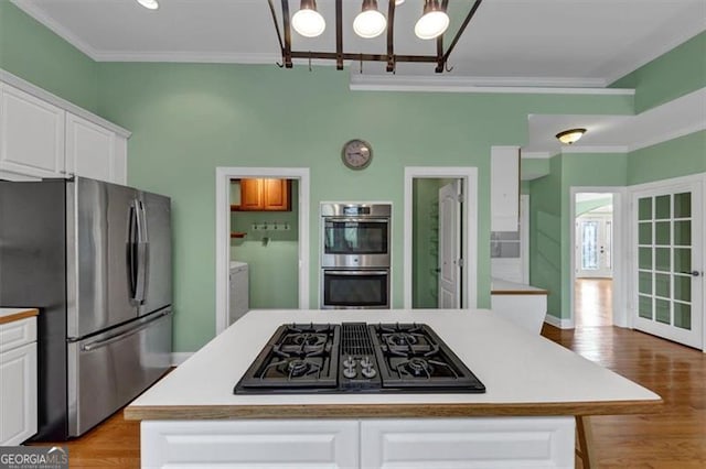 10890 Regal Frst, Suwanee, GA 30024 - kitchen featuring appliances with stainless steel finishes, crown molding, a chandelier, white cabinets, and light countertops