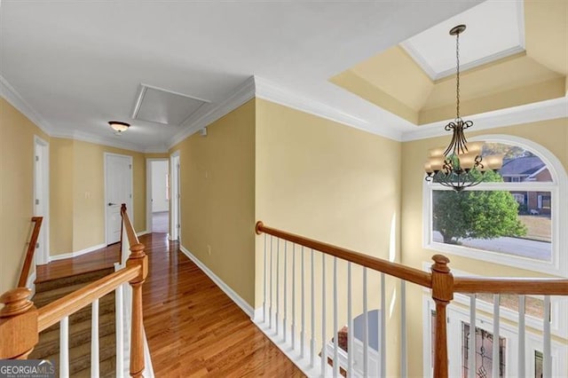 10890 Regal Frst, Suwanee, GA 30024 - hallway featuring attic access, an upstairs landing, wood finished floors, ornamental molding, and a chandelier