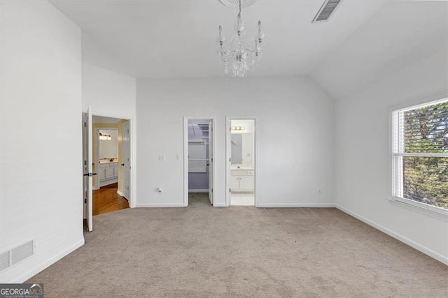 10890 Regal Frst, Suwanee, GA 30024 - unfurnished bedroom with a chandelier, carpet flooring, vaulted ceiling, a spacious closet, and connected bathroom