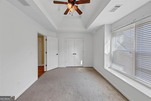10890 Regal Frst, Suwanee, GA 30024 - unfurnished bedroom with carpet floors, a tray ceiling, baseboards, and a closet