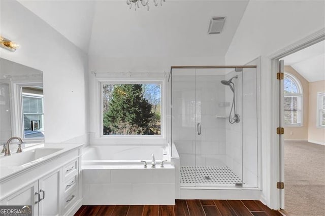 10890 Regal Frst, Suwanee, GA 30024 - bathroom featuring lofted ceiling, a stall shower, a bath, vanity, and wood finished floors