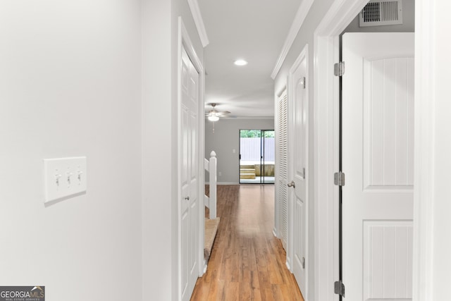 corridor featuring light wood-style flooring, recessed lighting, crown molding, and baseboards