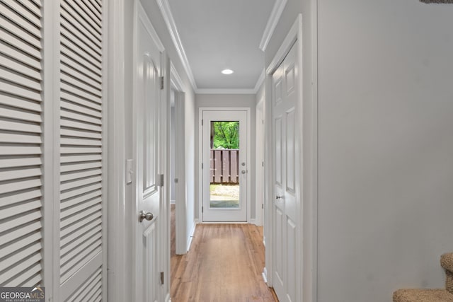 hall featuring light wood-style flooring, ornamental molding, baseboards, and recessed lighting