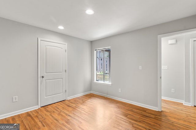 spare room featuring recessed lighting, baseboards, and light wood-style floors