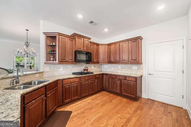 306 Cherokee Station Cir, Woodstock, GA 30188 - kitchen with black microwave, gas stovetop, open shelves, light stone countertops, and decorative backsplash