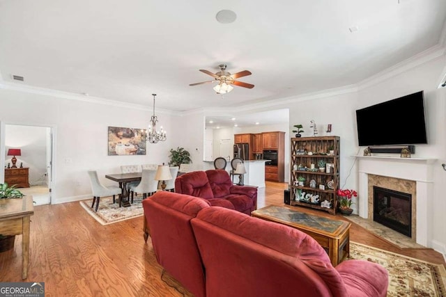 306 Cherokee Station Cir, Woodstock, GA 30188 - living room with a ceiling fan, crown molding, a high end fireplace, light wood-style flooring, and a chandelier
