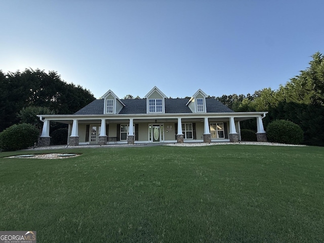 view of front of property featuring covered porch, a front yard, and stone siding