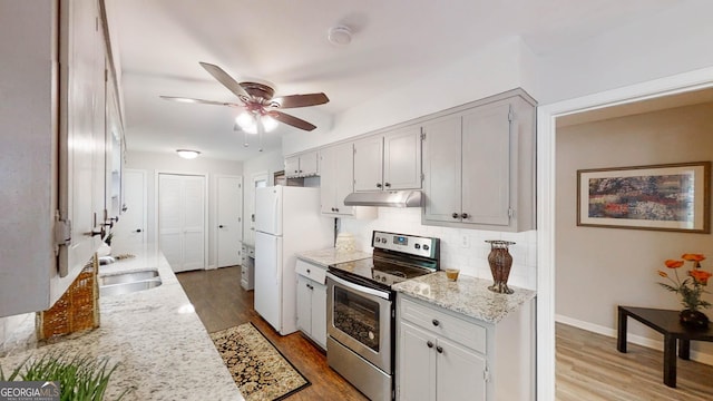 4244 Dorsey Ct SW, Lilburn, GA 30047 - kitchen featuring stainless steel electric range, under cabinet range hood, freestanding refrigerator, a ceiling fan, and tasteful backsplash