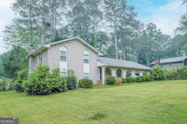 4244 Dorsey Ct SW, Lilburn, GA 30047 - split level home featuring a chimney, a front yard, and brick siding