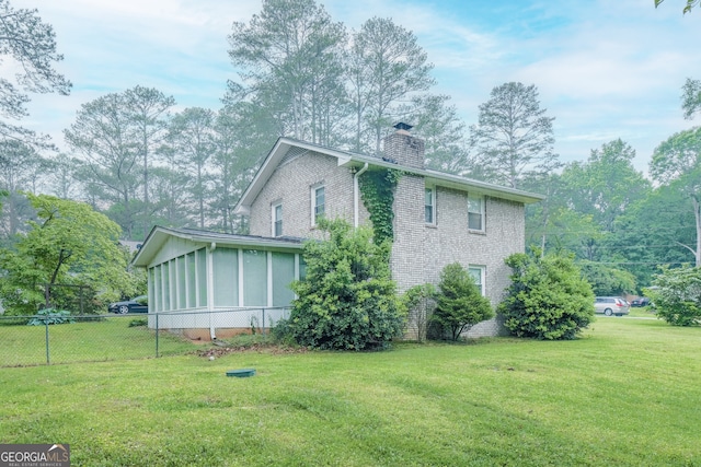 4244 Dorsey Ct SW, Lilburn, GA 30047 - view of property exterior featuring a chimney, a sunroom, and brick siding