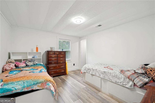 bedroom featuring wood finished floors and a textured ceiling