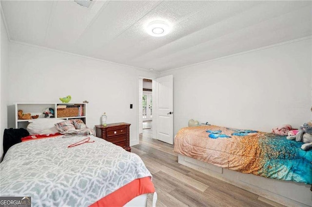 bedroom featuring crown molding and wood finished floors