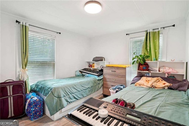 bedroom with multiple windows and wood finished floors