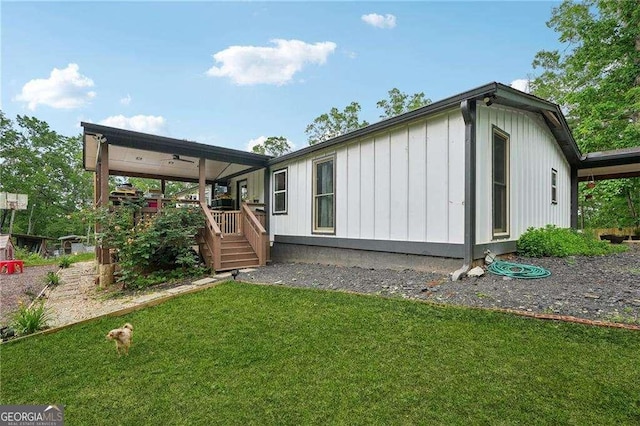 rear view of property with board and batten siding and a yard