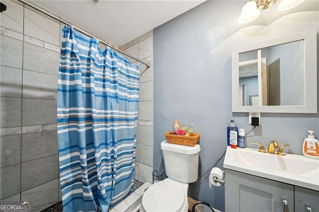 bathroom featuring tiled shower, vanity, and toilet