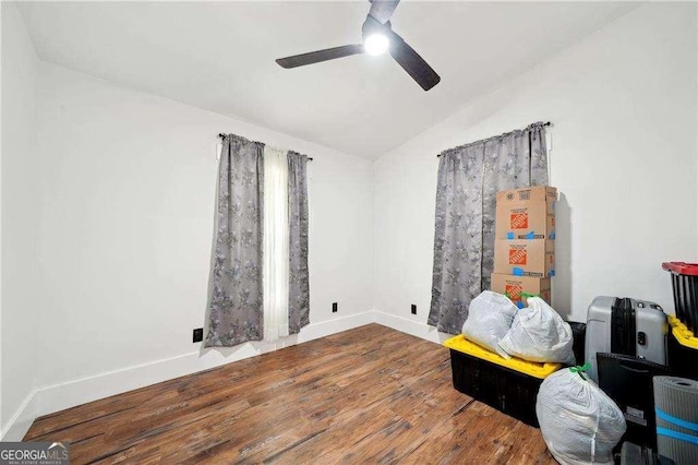 empty room with wood finished floors, ceiling fan, lofted ceiling, and baseboards