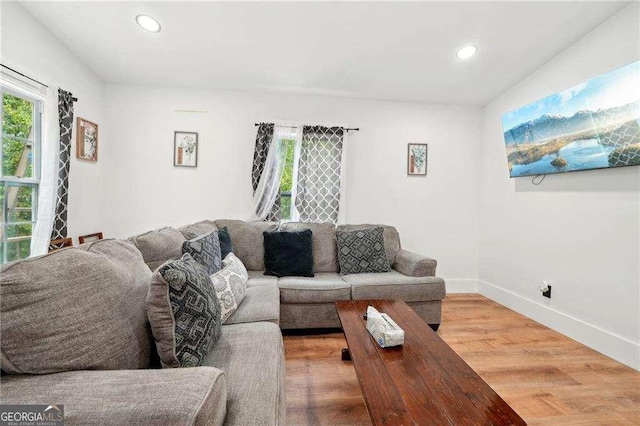living area featuring wood finished floors, healthy amount of natural light, recessed lighting, and baseboards