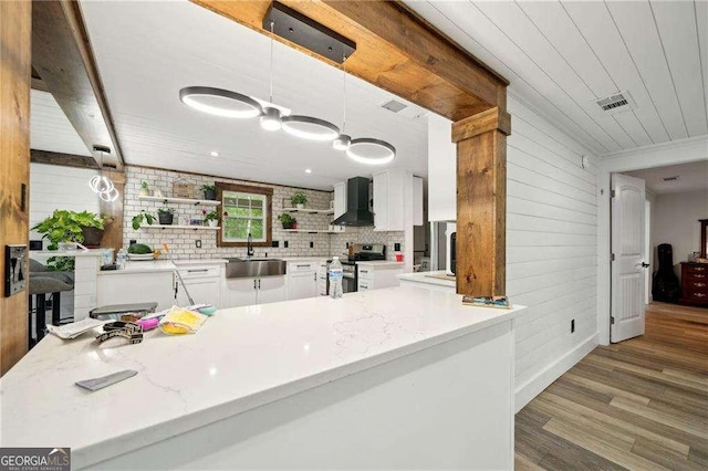 kitchen featuring a sink, stainless steel range with electric cooktop, wall chimney exhaust hood, white cabinets, and open shelves