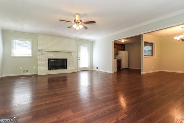 5243 Valleyview Dr, Acworth, GA 30102 - unfurnished living room with plenty of natural light, a ceiling fan, a chandelier, dark wood-style flooring, and ornamental molding