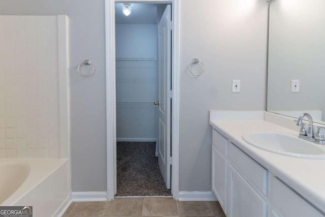 7623 Mcgillicuty Dr, Union City, GA 30291 - full bathroom with tile patterned flooring, vanity, a walk in closet, and baseboards