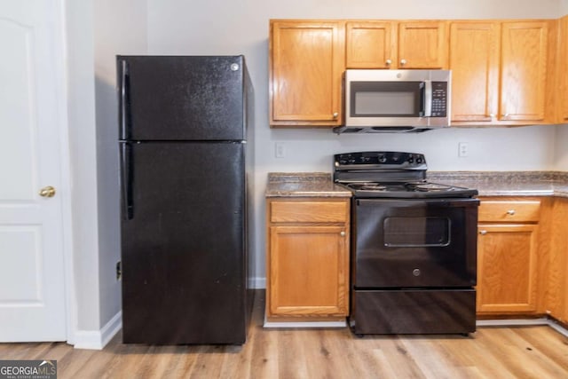 7623 Mcgillicuty Dr, Union City, GA 30291 - kitchen with black appliances, light wood-style flooring, baseboards, and dark countertops