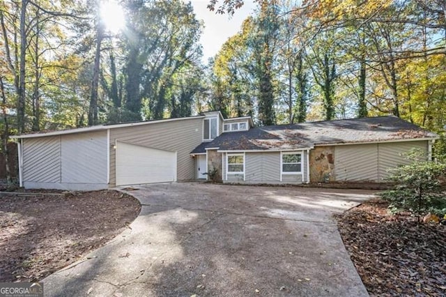 mid-century inspired home with driveway and an attached garage