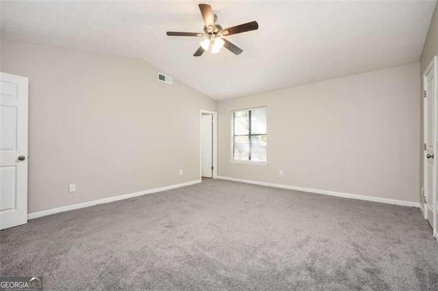carpeted empty room with ceiling fan, baseboards, and vaulted ceiling