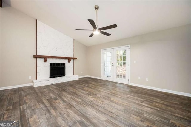 unfurnished living room featuring ceiling fan, lofted ceiling, wood finished floors, a fireplace, and baseboards