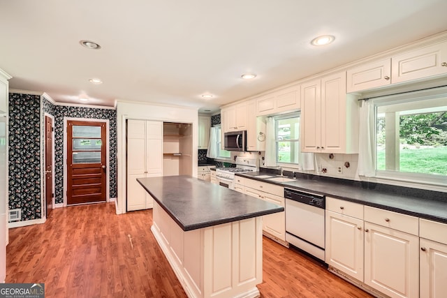 5401 Smoke Rise Dr, Smoke Rise, GA 30087 - kitchen with white appliances, ornamental molding, dark countertops, light wood-style flooring, and a kitchen island