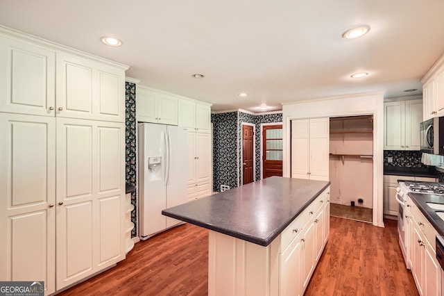 5401 Smoke Rise Dr, Smoke Rise, GA 30087 - kitchen with white appliances, dark countertops, a center island, wood finished floors, and white cabinets