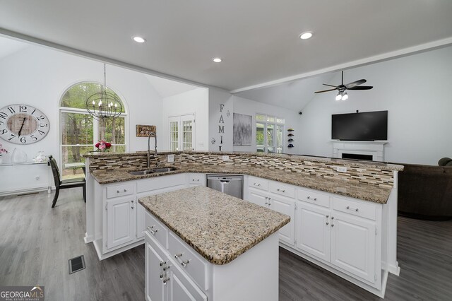 20 Allie Dr, Mcdonough, GA 30252 - kitchen featuring a sink, a center island, lofted ceiling, stainless steel dishwasher, and dark wood-style flooring