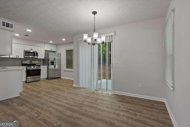 5383 Biffle Way, Stone Mountain, GA 30088 - kitchen featuring appliances with stainless steel finishes, baseboards, a chandelier, dark wood finished floors, and white cabinetry