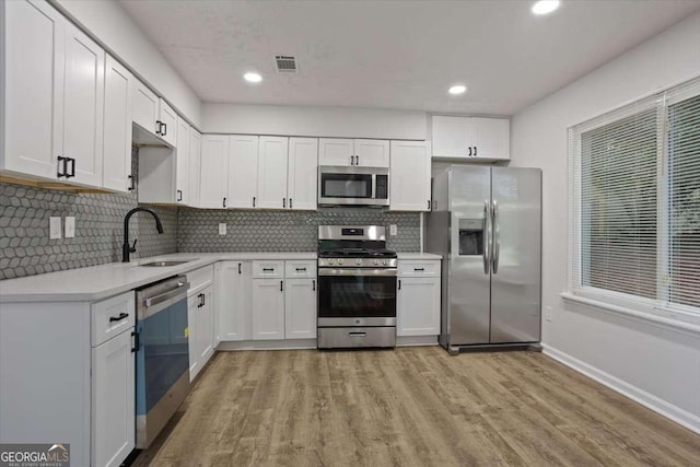 5383 Biffle Way, Stone Mountain, GA 30088 - kitchen featuring stainless steel appliances, a sink, light wood-type flooring, tasteful backsplash, and recessed lighting