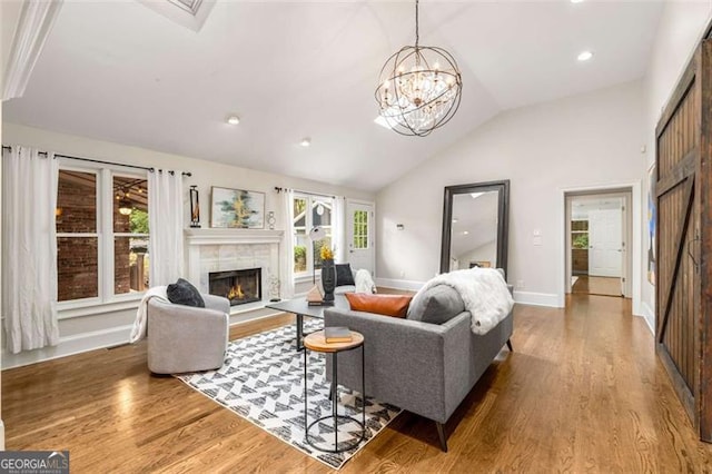 1041 Standard Dr, Brookhaven, GA 30319 - living room featuring wood finished floors, a tiled fireplace, vaulted ceiling, healthy amount of natural light, and baseboards