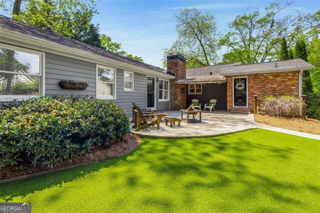 1041 Standard Dr, Brookhaven, GA 30319 - rear view of house with a chimney, a lawn, and a patio area