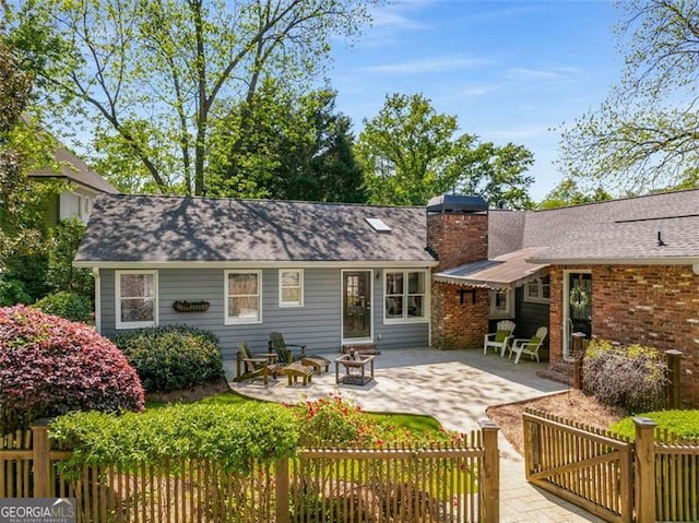 1041 Standard Dr, Brookhaven, GA 30319 - rear view of house with a patio, a chimney, and an outdoor fire pit