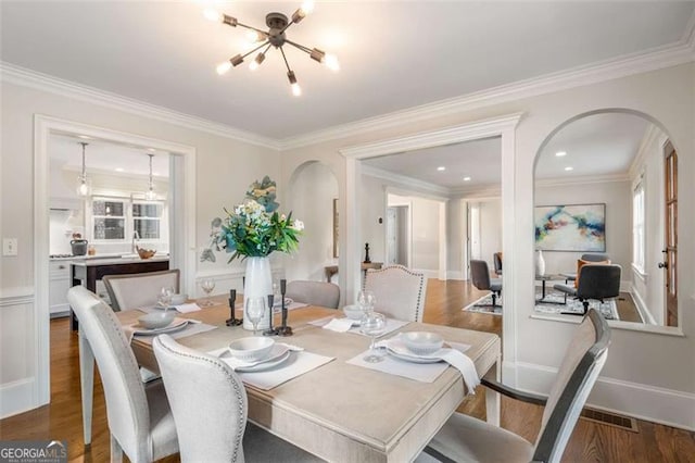 1041 Standard Dr, Brookhaven, GA 30319 - dining area featuring a chandelier, arched walkways, wood finished floors, and ornamental molding