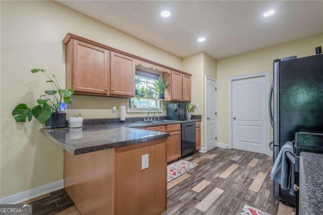 188 Cooper Creek Dr, Dallas, GA 30157 - kitchen with black dishwasher, a peninsula, dark wood-type flooring, a sink, and brown cabinets