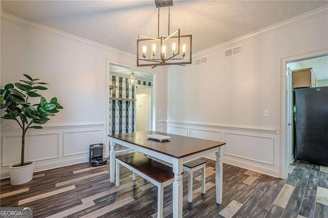 188 Cooper Creek Dr, Dallas, GA 30157 - dining room with wood finished floors, a chandelier, a decorative wall, crown molding, and a wainscoted wall