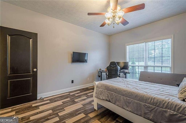 188 Cooper Creek Dr, Dallas, GA 30157 - bedroom with baseboards, a textured ceiling, wood finished floors, a ceiling fan, and an office area