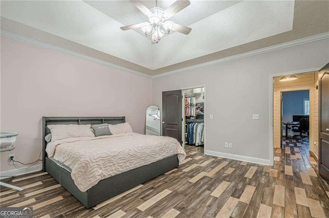 188 Cooper Creek Dr, Dallas, GA 30157 - bedroom with wood finished floors, a walk in closet, crown molding, a raised ceiling, and baseboards