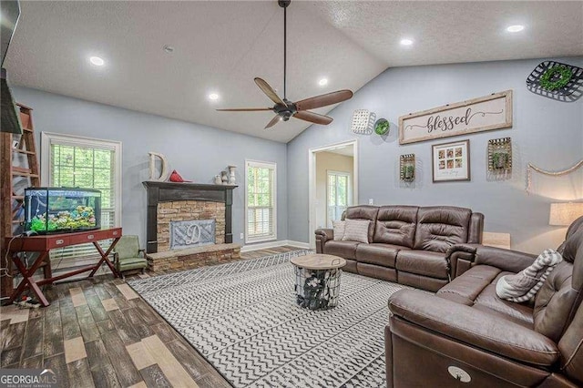 188 Cooper Creek Dr, Dallas, GA 30157 - living room featuring wood finished floors, ceiling fan, vaulted ceiling, a stone fireplace, and healthy amount of natural light