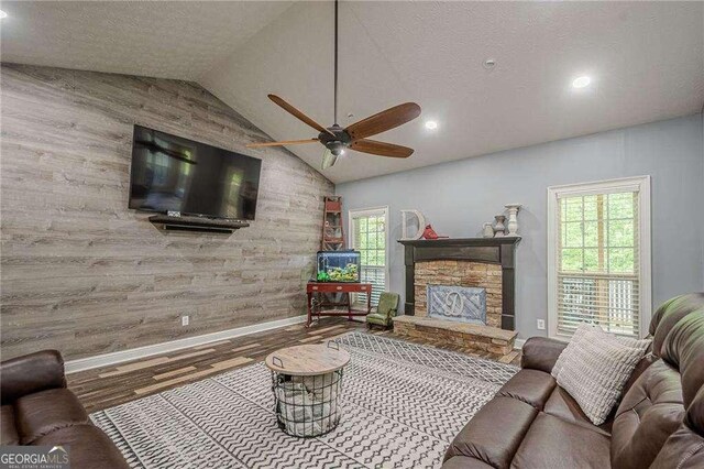 188 Cooper Creek Dr, Dallas, GA 30157 - living room with baseboards, wood finished floors, vaulted ceiling, a ceiling fan, and a stone fireplace