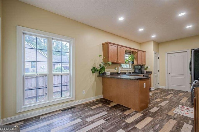 188 Cooper Creek Dr, Dallas, GA 30157 - kitchen featuring dark wood-style flooring, a peninsula, recessed lighting, baseboards, and brown cabinets