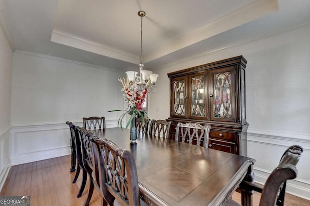 25 Kaktovic Ct, Grayson, GA 30017 - dining room with a tray ceiling, a chandelier, wood-type flooring, ornamental molding, and wainscoting
