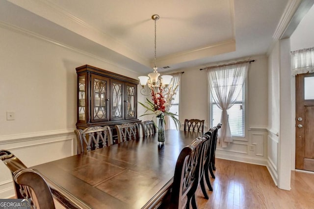 25 Kaktovic Ct, Grayson, GA 30017 - dining space with a chandelier, light wood-style floors, a raised ceiling, ornamental molding, and wainscoting