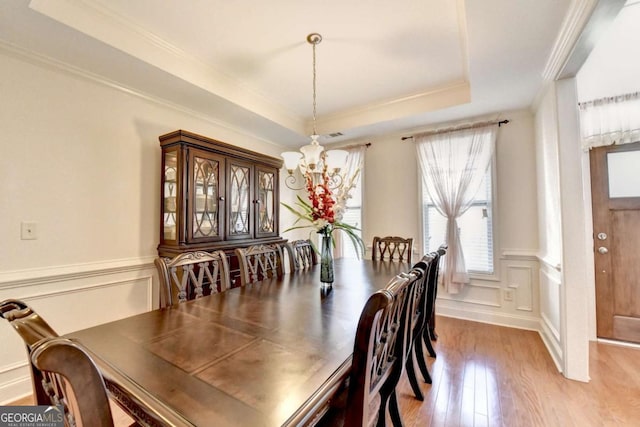 25 Kaktovic Ct, Grayson, GA 30017 - dining room featuring a chandelier, hardwood / wood-style floors, a raised ceiling, crown molding, and a wainscoted wall