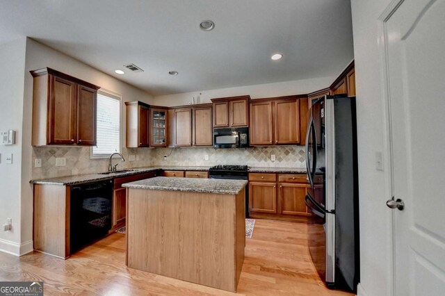 25 Kaktovic Ct, Grayson, GA 30017 - kitchen featuring black appliances, light wood finished floors, light stone countertops, a kitchen island, and recessed lighting