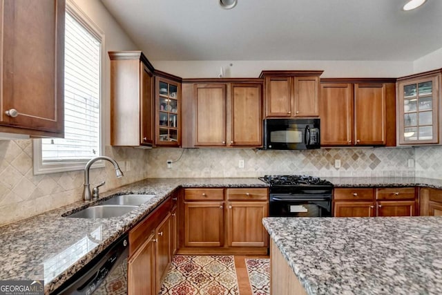 25 Kaktovic Ct, Grayson, GA 30017 - kitchen with black appliances, a sink, light stone countertops, brown cabinets, and glass insert cabinets